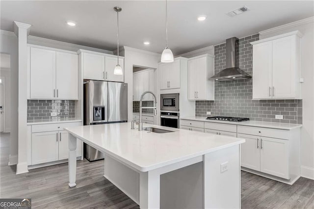 kitchen with white cabinetry, sink, wall chimney range hood, and a center island with sink