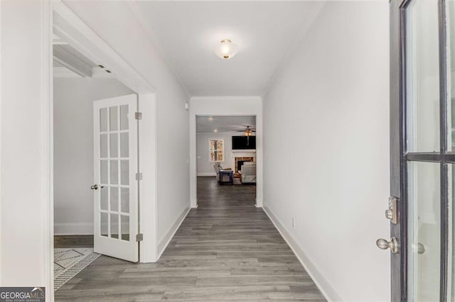 hallway with crown molding and light hardwood / wood-style flooring