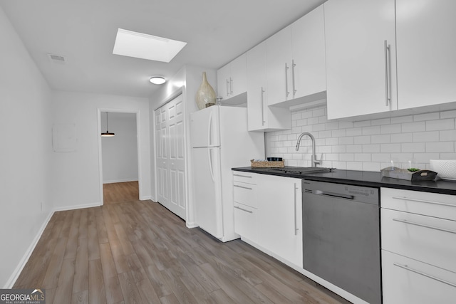 kitchen with backsplash, stainless steel dishwasher, sink, white fridge, and white cabinetry