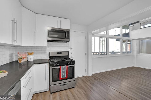 kitchen with white cabinets, light wood-type flooring, backsplash, and appliances with stainless steel finishes