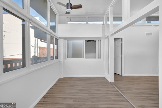 unfurnished sunroom with ceiling fan