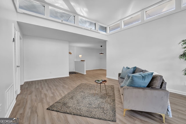 sitting room with a high ceiling and light wood-type flooring