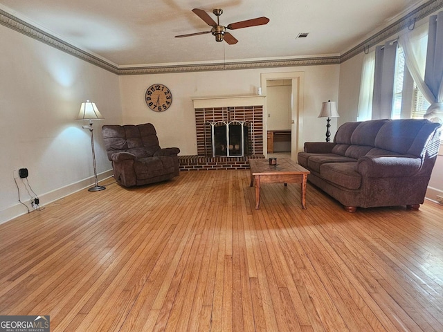 living area with ornamental molding, light wood-type flooring, a brick fireplace, and baseboards