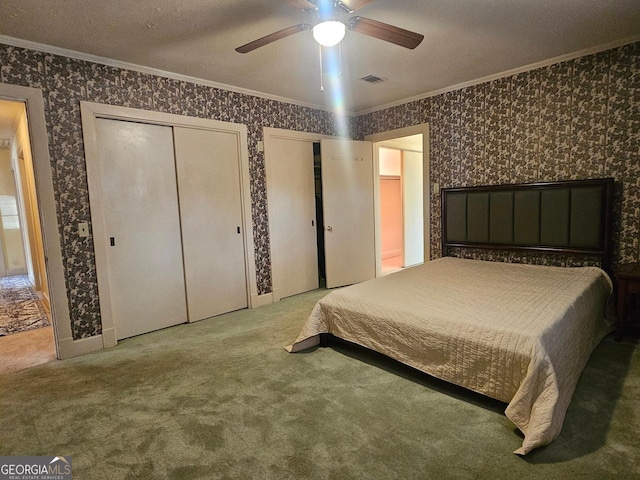 bedroom with multiple closets, carpet, visible vents, and wallpapered walls