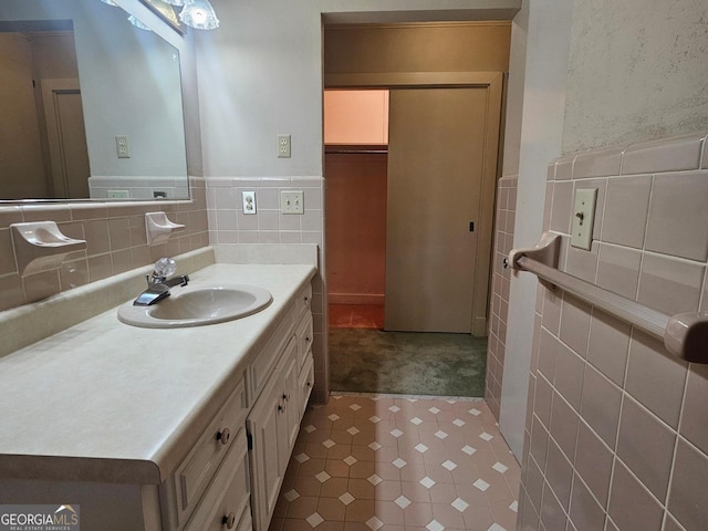 bathroom featuring wainscoting, vanity, and tile walls