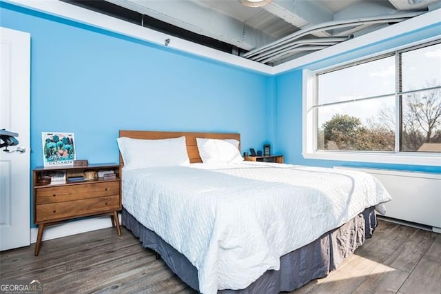 bedroom with dark hardwood / wood-style flooring