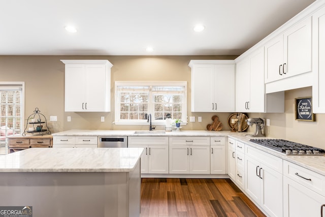 kitchen featuring light stone countertops, stainless steel appliances, dark wood-type flooring, sink, and white cabinetry