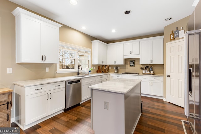 kitchen featuring sink, a kitchen island, light stone counters, white cabinets, and appliances with stainless steel finishes