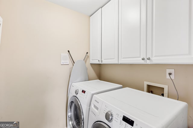 laundry area with cabinets and washing machine and clothes dryer