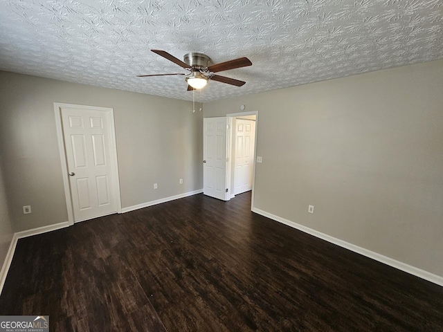 unfurnished bedroom with a textured ceiling, ceiling fan, and dark hardwood / wood-style flooring