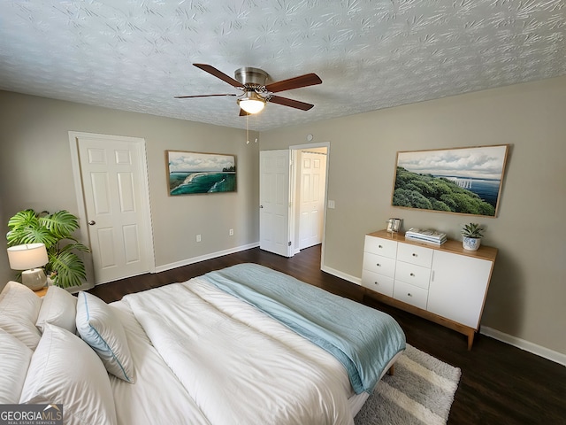 bedroom featuring a textured ceiling, ceiling fan, and dark hardwood / wood-style floors