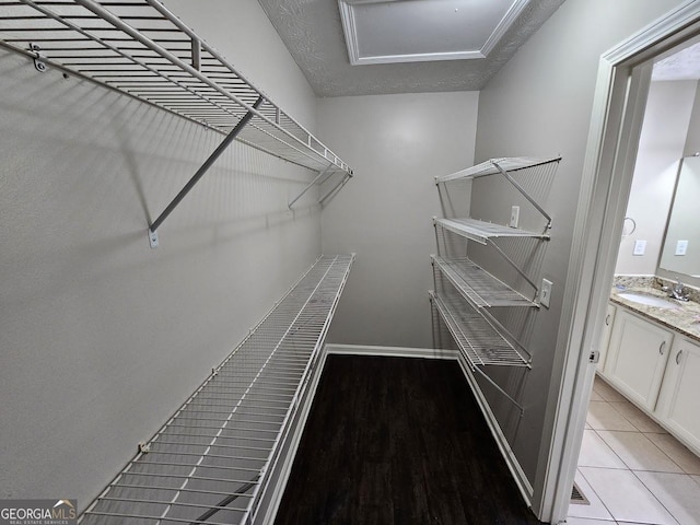 spacious closet with light tile patterned floors and sink