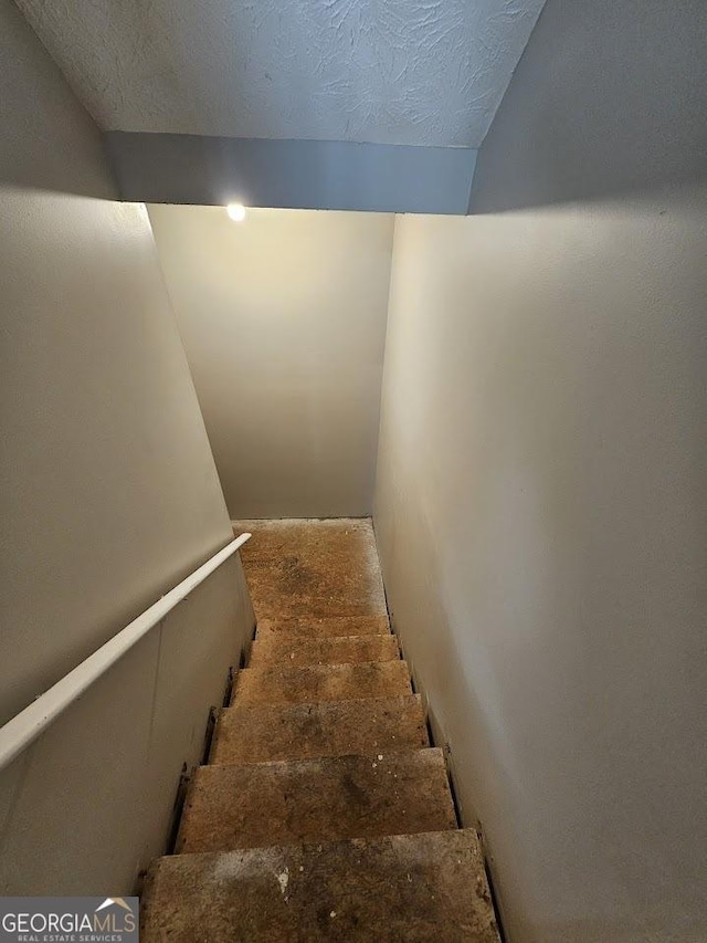 staircase with a textured ceiling