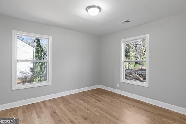 empty room with light hardwood / wood-style flooring and a healthy amount of sunlight