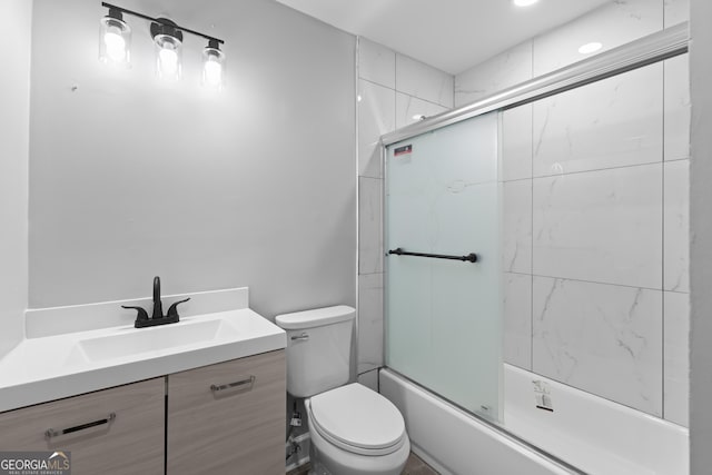 full bathroom featuring shower / bath combination with glass door, vanity, and toilet