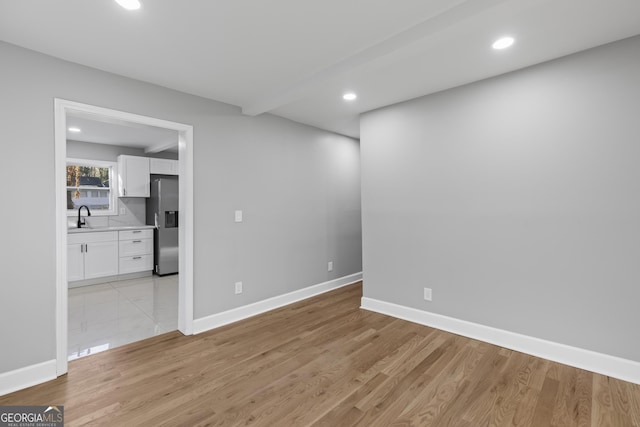 spare room with light hardwood / wood-style flooring and sink