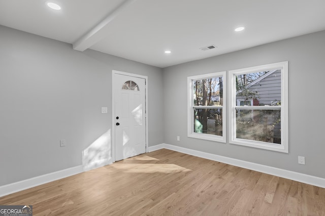 foyer entrance with beamed ceiling and light wood-type flooring