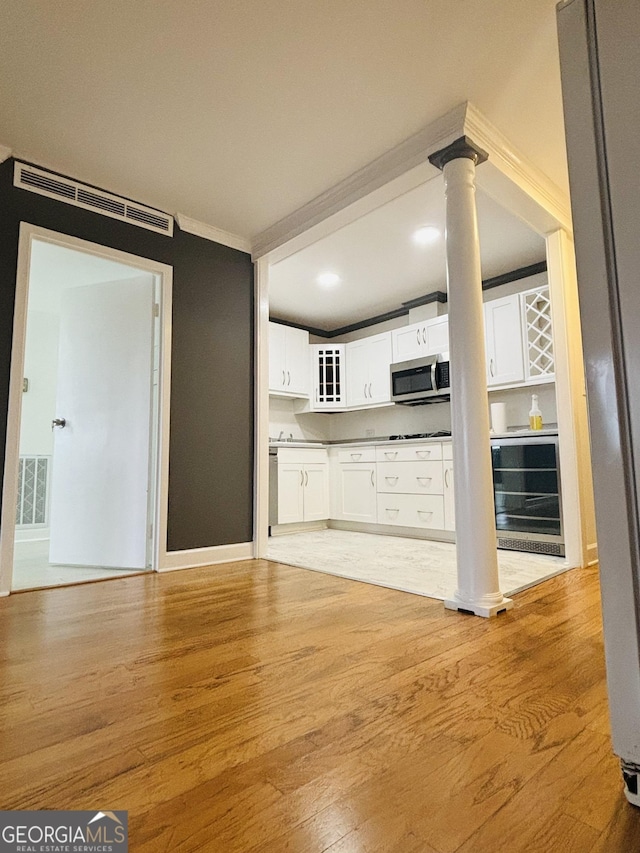 kitchen featuring wine cooler, white cabinetry, and light wood-type flooring