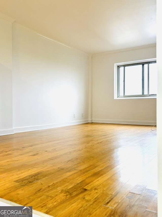 unfurnished room featuring light hardwood / wood-style floors and ornamental molding