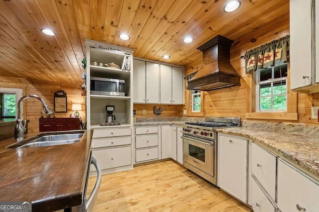 kitchen with wooden ceiling, premium range hood, white cabinets, sink, and appliances with stainless steel finishes