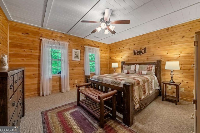 bedroom featuring light carpet, ceiling fan, and wooden walls