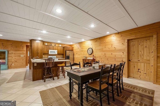 tiled dining area featuring wooden walls