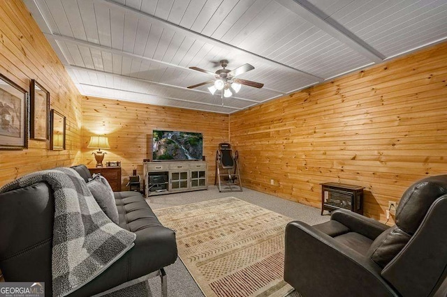 living room with carpet flooring, wooden walls, and ceiling fan