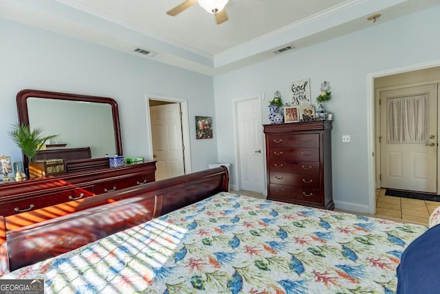 tiled bedroom featuring a raised ceiling, ceiling fan, and ornamental molding