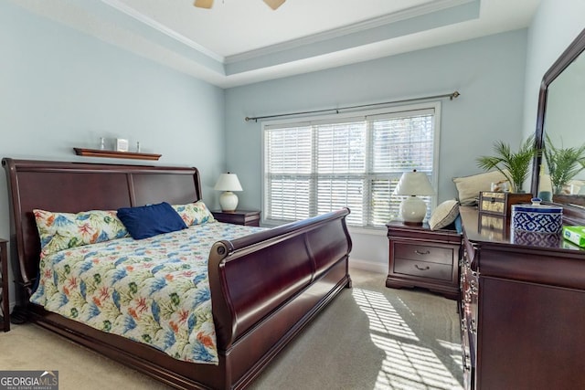 bedroom with a tray ceiling, ceiling fan, light colored carpet, and ornamental molding