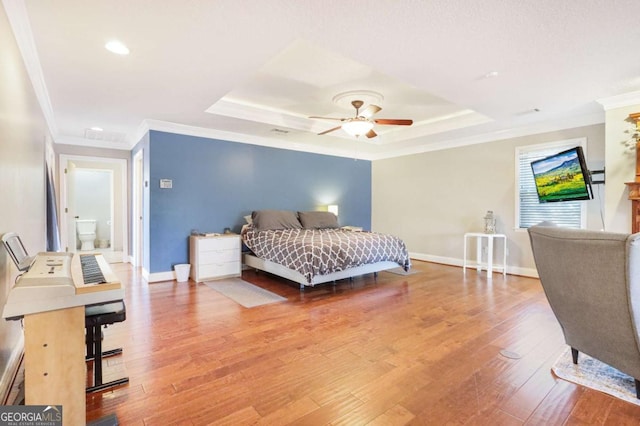 bedroom featuring hardwood / wood-style flooring, ceiling fan, and a tray ceiling