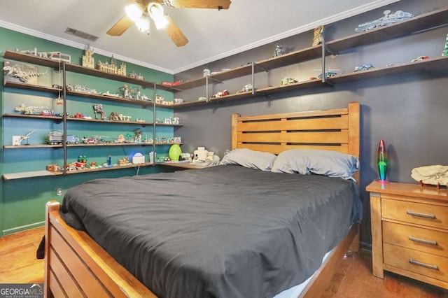 bedroom with ceiling fan, hardwood / wood-style floors, and ornamental molding