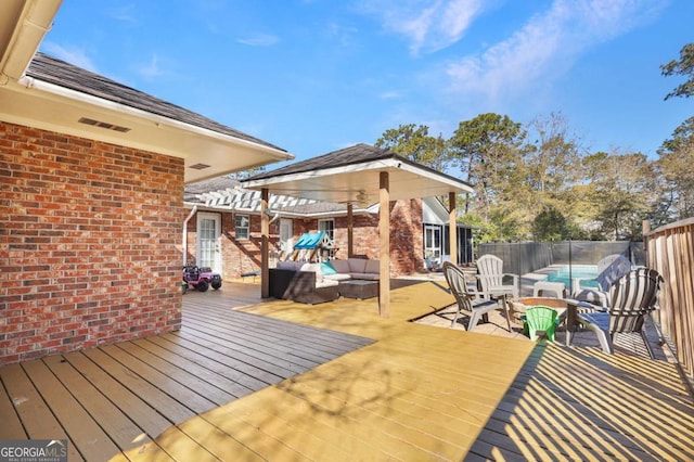 wooden deck with outdoor lounge area and a fenced in pool