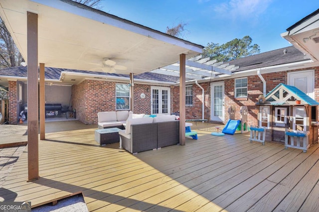 wooden deck featuring outdoor lounge area, ceiling fan, and area for grilling