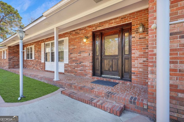 property entrance with a yard and a porch