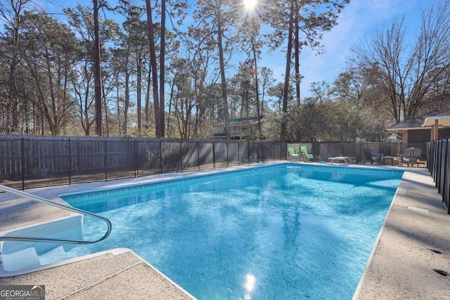 view of swimming pool featuring a diving board