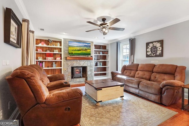 living room featuring built in features, crown molding, and a wood stove