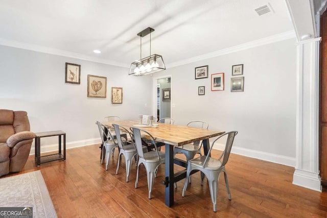 dining area with hardwood / wood-style flooring and crown molding