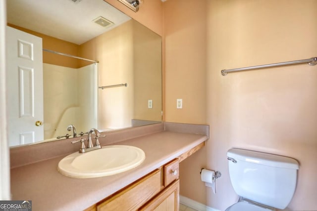 bathroom with vanity, toilet, and walk in shower