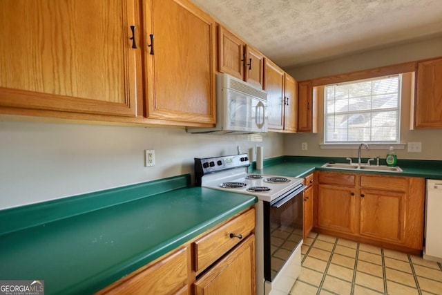 kitchen with a textured ceiling, white appliances, sink, and light tile patterned floors