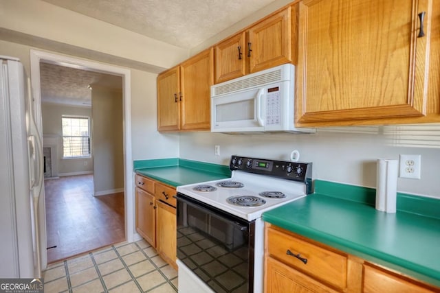 kitchen featuring light tile patterned flooring, white appliances, and a textured ceiling