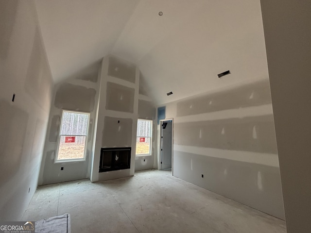 unfurnished living room featuring high vaulted ceiling