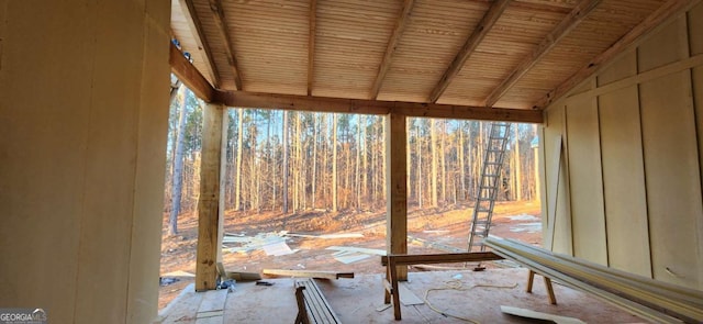 unfurnished sunroom featuring lofted ceiling with beams