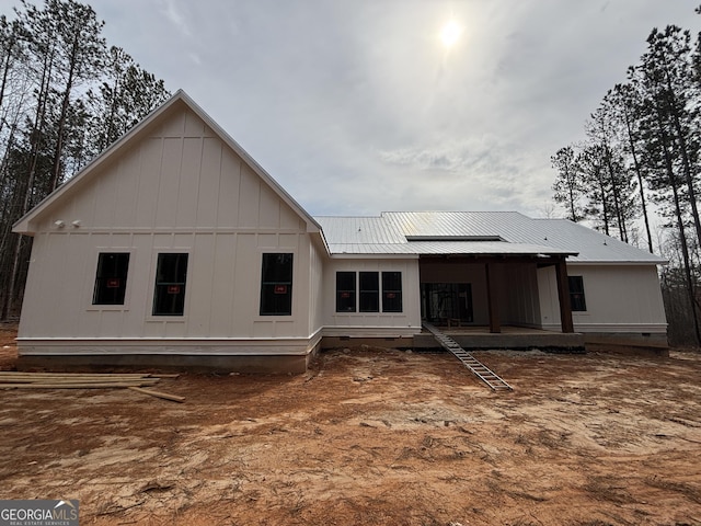 rear view of house with crawl space, metal roof, and a deck