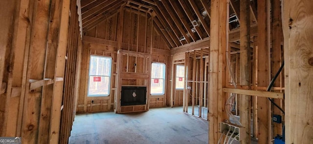 misc room with a multi sided fireplace and lofted ceiling