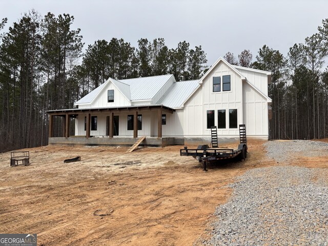 view of front of property with covered porch and a fire pit