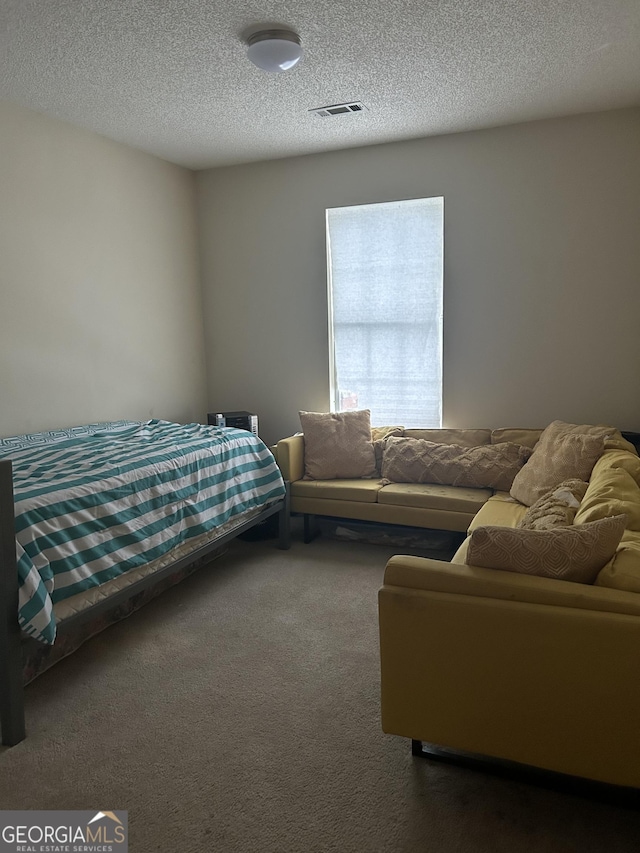 bedroom featuring carpet floors and a textured ceiling