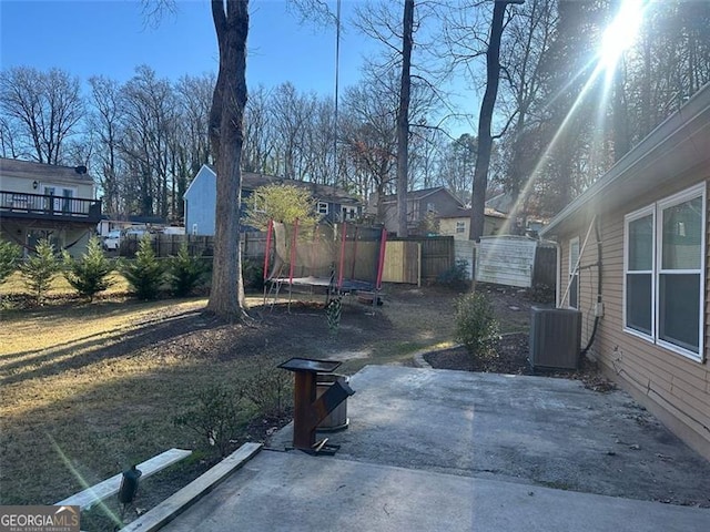 view of yard featuring a patio, central AC unit, and a trampoline