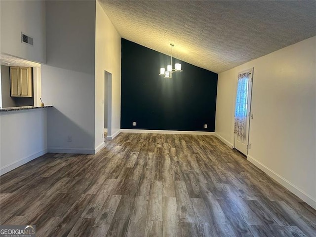 interior space with dark hardwood / wood-style flooring, lofted ceiling, a textured ceiling, and an inviting chandelier