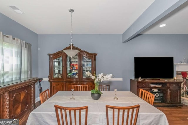 dining room with beamed ceiling and hardwood / wood-style flooring