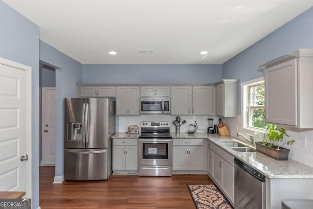 kitchen with gray cabinetry, dark hardwood / wood-style floors, sink, and stainless steel appliances